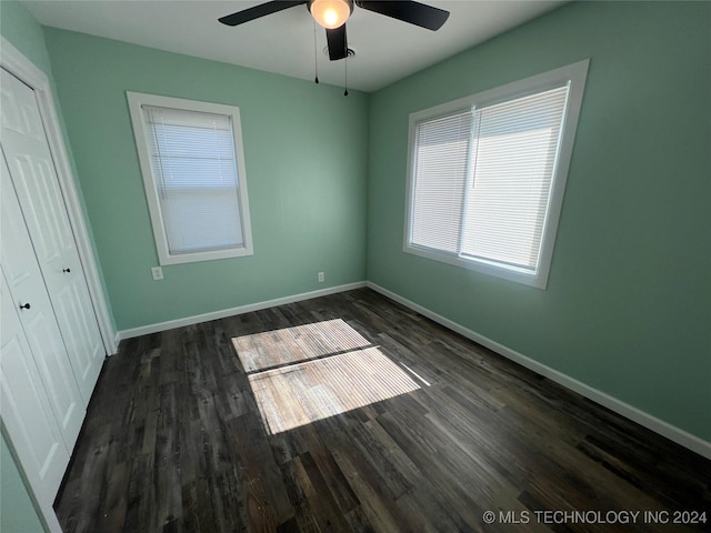 unfurnished bedroom with ceiling fan and dark hardwood / wood-style flooring