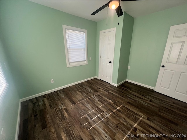 unfurnished bedroom featuring ceiling fan and dark hardwood / wood-style flooring