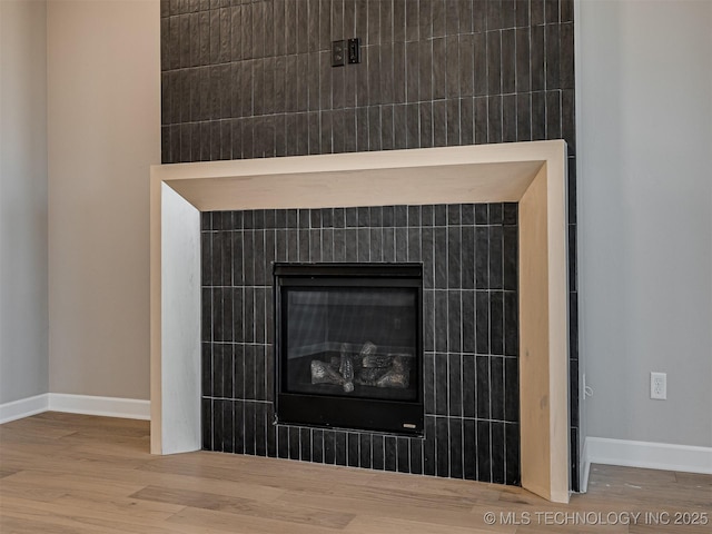 room details featuring hardwood / wood-style flooring and a tiled fireplace