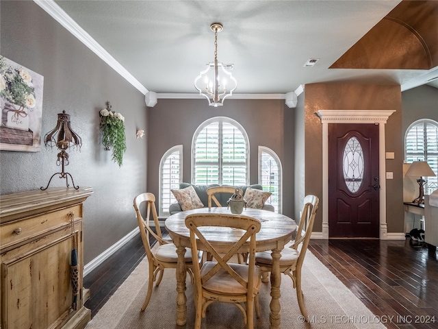 dining area featuring dark wood-type flooring, a notable chandelier, and crown molding