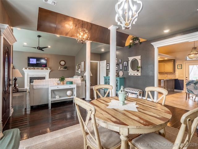 dining room with ornate columns, ceiling fan, wood-type flooring, and vaulted ceiling