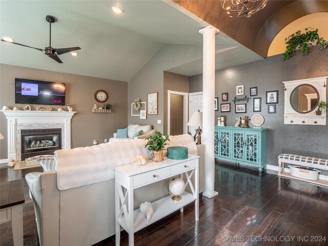 living room featuring decorative columns, vaulted ceiling, dark hardwood / wood-style flooring, a fireplace, and ceiling fan