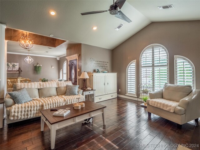 living room featuring ornamental molding, dark hardwood / wood-style floors, ceiling fan with notable chandelier, and vaulted ceiling