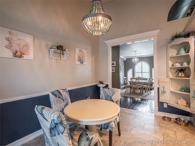 dining room featuring a notable chandelier, wood-type flooring, and ornamental molding