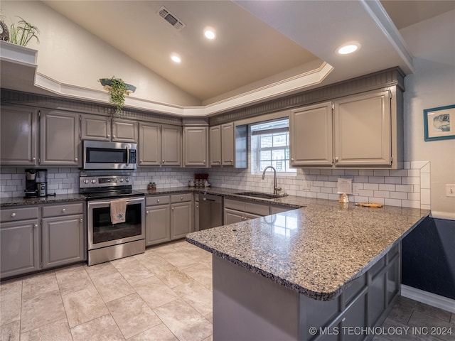 kitchen featuring kitchen peninsula, vaulted ceiling, sink, gray cabinets, and stainless steel appliances