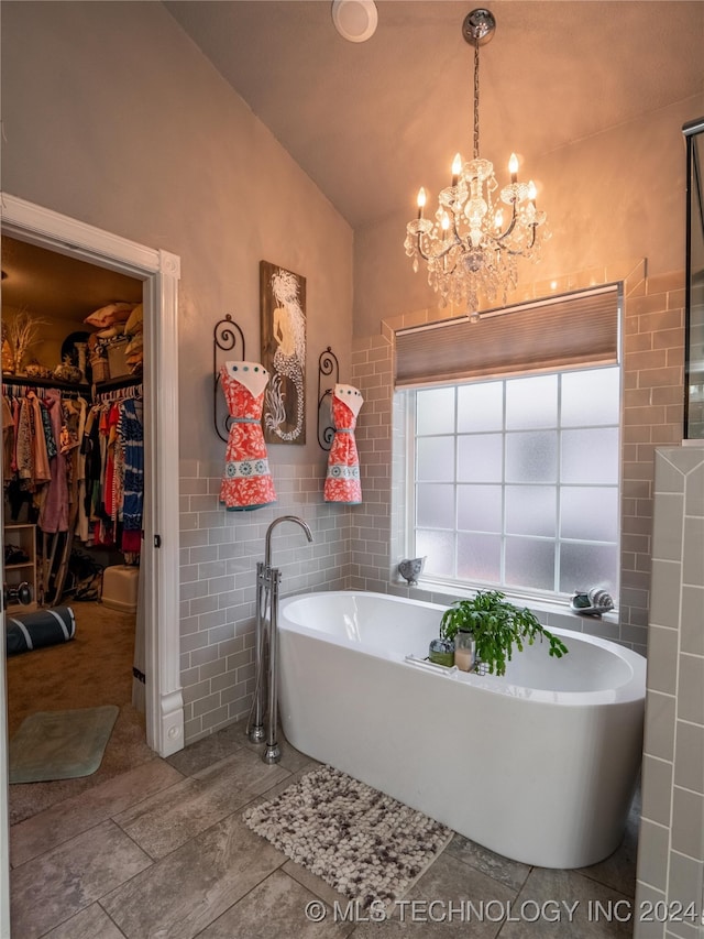 bathroom with tile walls, lofted ceiling, and a tub to relax in