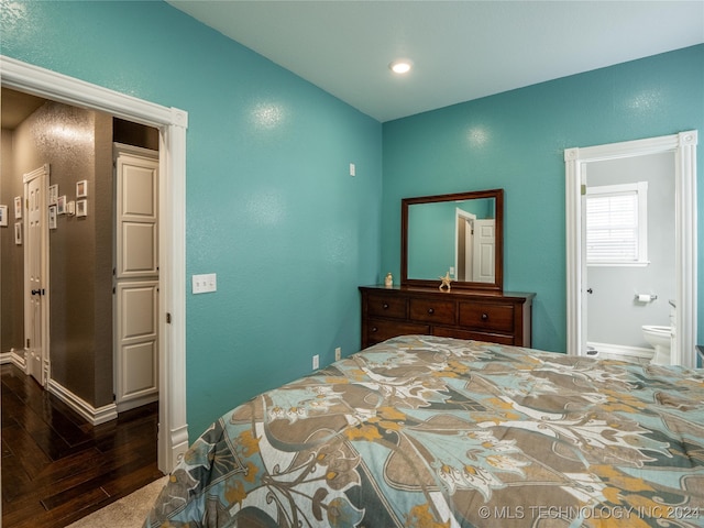 bedroom featuring dark parquet flooring and connected bathroom