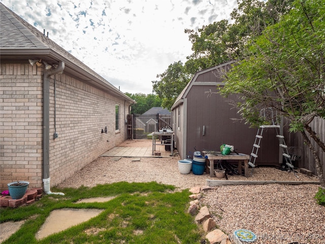 view of yard featuring a patio and a shed