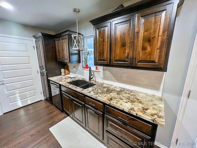 kitchen featuring dark wood-type flooring, hanging light fixtures, sink, stainless steel dishwasher, and light stone counters