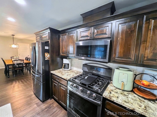 kitchen featuring dark brown cabinets, decorative light fixtures, stainless steel appliances, and wood-type flooring