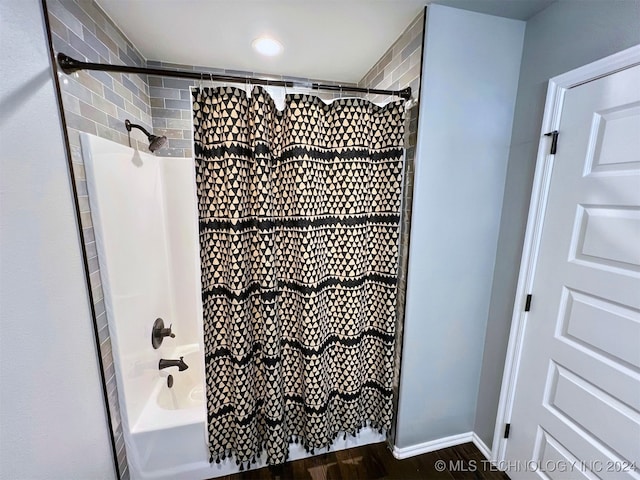 bathroom with shower / tub combo with curtain and hardwood / wood-style flooring