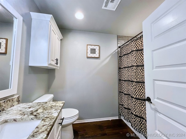 bathroom featuring vanity, hardwood / wood-style floors, a shower with shower curtain, and toilet