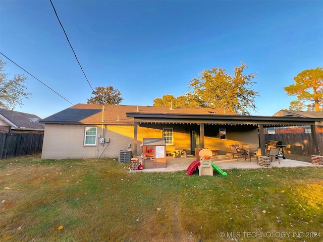 rear view of property featuring a patio area, a lawn, and central AC unit