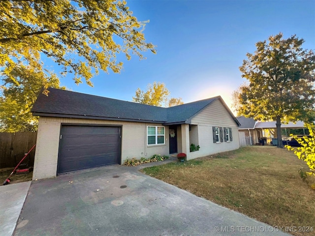 single story home with a garage and a lawn