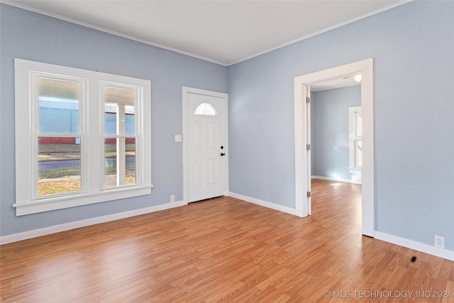 foyer entrance with light hardwood / wood-style floors and ornamental molding