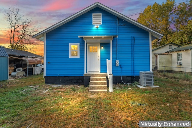 view of front of house with central AC unit, cooling unit, and a lawn