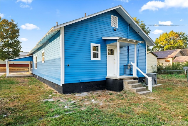 view of front of property with a front lawn and cooling unit