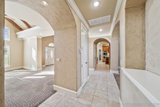 corridor with crown molding, lofted ceiling, and light tile patterned flooring