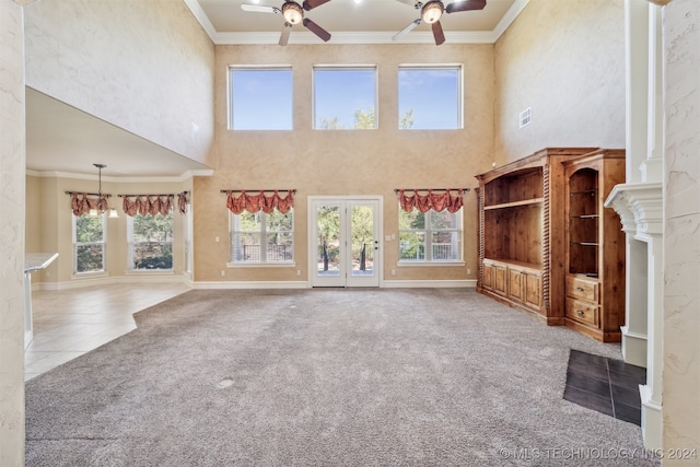 unfurnished living room featuring a wealth of natural light, ornamental molding, a high ceiling, and ceiling fan with notable chandelier