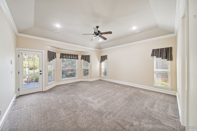 carpeted spare room with crown molding, a tray ceiling, and ceiling fan