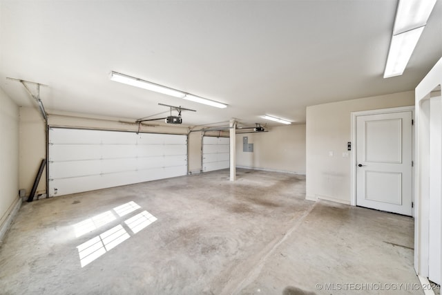 garage with a garage door opener and electric panel