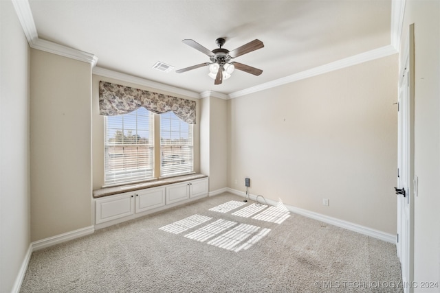 spare room featuring ceiling fan, crown molding, and light colored carpet