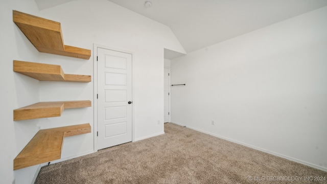 unfurnished bedroom with lofted ceiling and light colored carpet