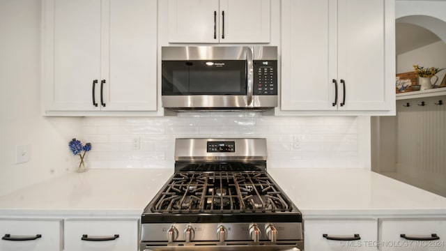 kitchen with white cabinets, stainless steel appliances, and tasteful backsplash