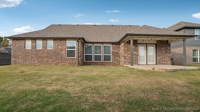 rear view of property featuring a patio area and a lawn