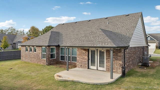 rear view of house featuring cooling unit, a patio area, and a lawn