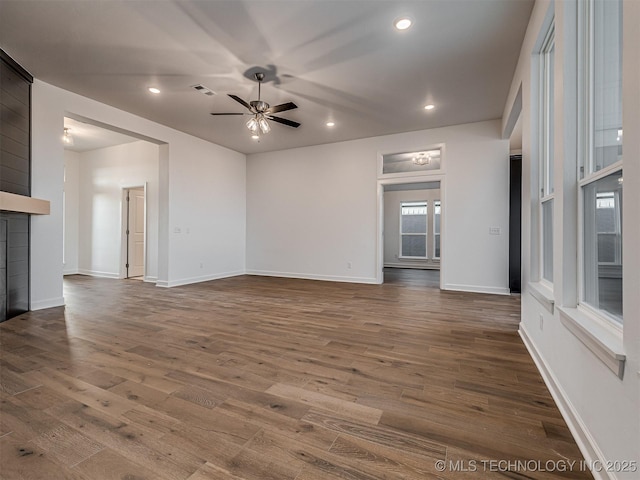 unfurnished living room featuring hardwood / wood-style floors, ceiling fan, and a fireplace