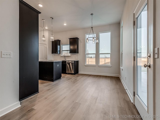 kitchen with a chandelier, light hardwood / wood-style flooring, pendant lighting, and stainless steel dishwasher