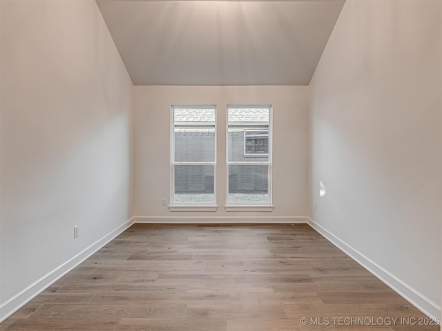 unfurnished room featuring light hardwood / wood-style flooring and lofted ceiling