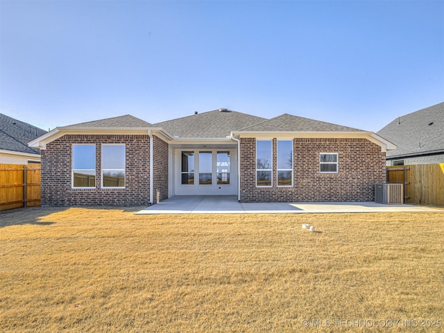 back of property with a lawn, cooling unit, and a patio area