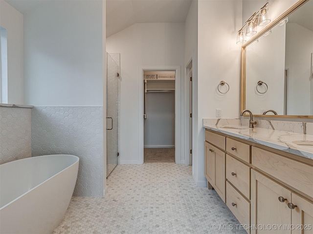 bathroom with shower with separate bathtub, vanity, and vaulted ceiling