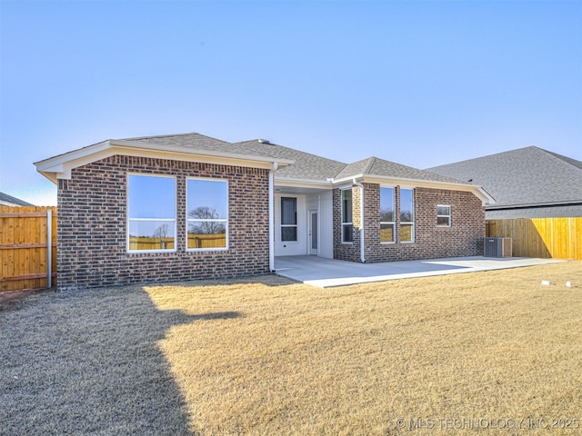 rear view of property featuring cooling unit, a patio area, and a lawn