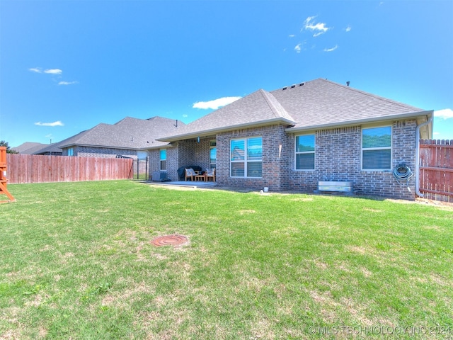 back of house with a patio and a yard