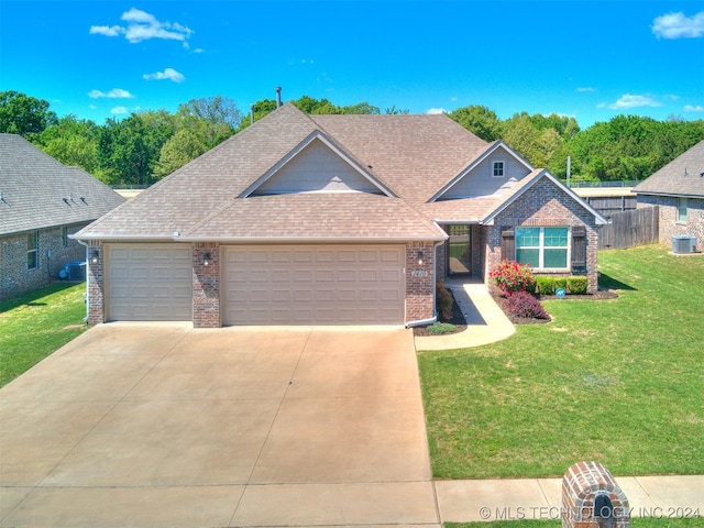 craftsman-style house featuring central air condition unit, a front yard, and a garage