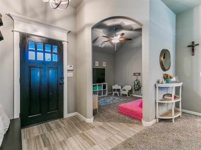 carpeted entrance foyer featuring lofted ceiling and ceiling fan