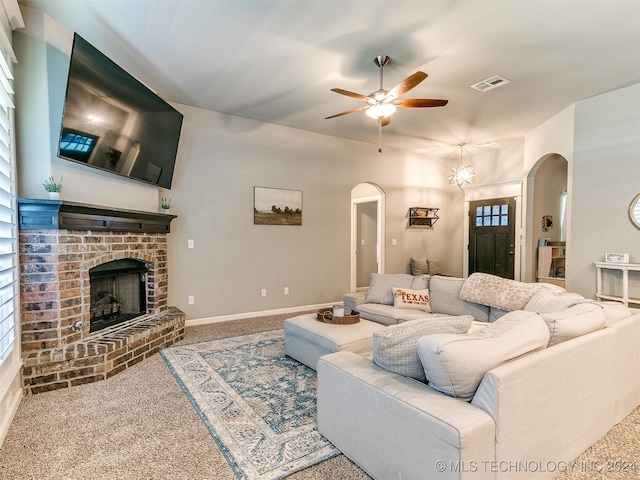 carpeted living room featuring a brick fireplace, ceiling fan, and a wealth of natural light