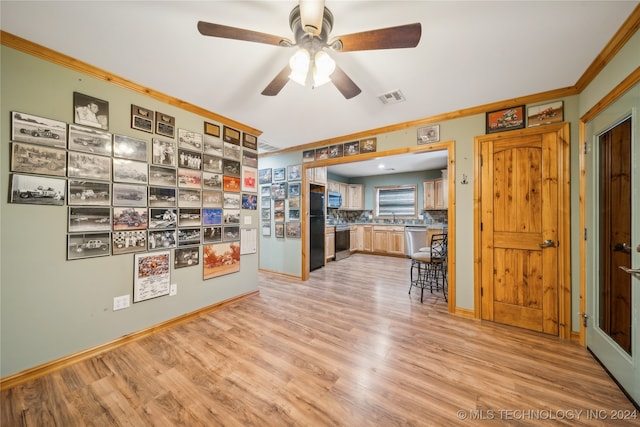 kitchen with ornamental molding, tasteful backsplash, appliances with stainless steel finishes, light hardwood / wood-style floors, and ceiling fan