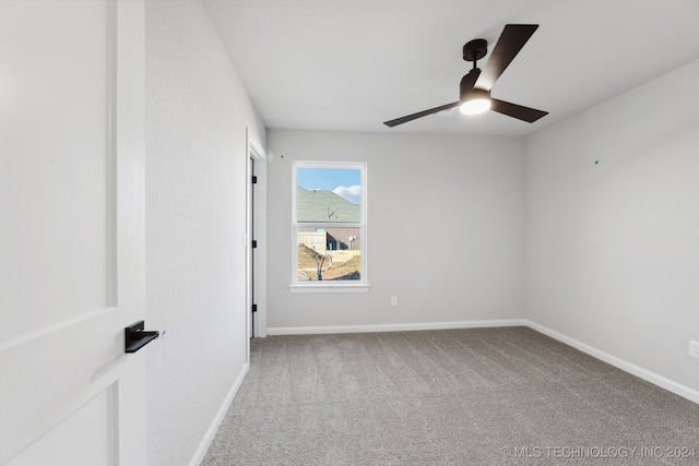 carpeted spare room with ceiling fan