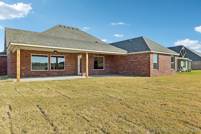 rear view of property featuring a yard and a patio area