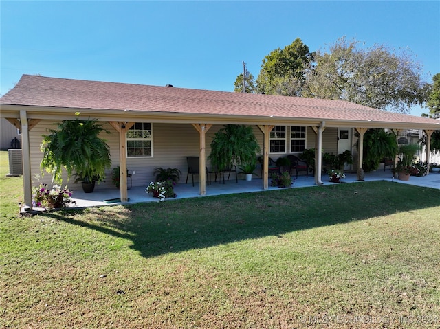 view of front facade with a front yard, a patio area, and central AC unit