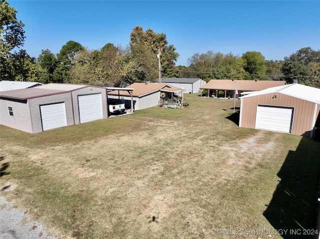 view of yard with a garage, an outbuilding, and a carport