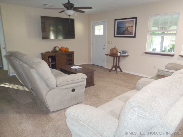 living room featuring ceiling fan, a wealth of natural light, and light colored carpet