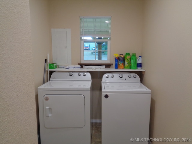 washroom with electric panel and washer and clothes dryer