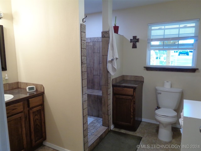 bathroom featuring vanity, toilet, a shower, and tile patterned flooring