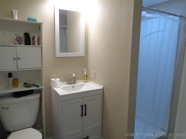 bathroom with vanity, curtained shower, and toilet