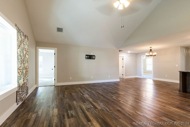 unfurnished living room with ceiling fan with notable chandelier, high vaulted ceiling, and dark hardwood / wood-style flooring